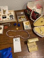 Wooden bead necklace, assorted pins and earrings in boxes, and small jewelry cases.