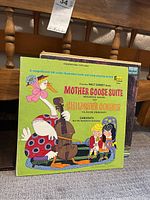 Photo of Walt Disney Mother Goose Suite and Children's Corner vinyl record cover with colorful illustrated stork playing cello and two children seated