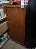 Side view showing the wood grain paneling and overall height of the dresser.