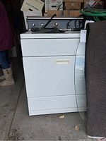 Front view of white Kenmore dryer, showing door and part of control panel with knobs on top.
