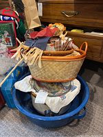 Woven autumn baskets stacked inside large blue enamel bowl with Rival Crock-Pot at the bottom, various autumn-themed fabric pieces including scarecrow visible in baskets