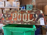Front view of rectangular pool table light with intricate stained glass style plastic panels showing decorative patterns in red, orange, and cream colors.