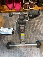 Top down view of the Gold's Gym under desk cycle showing pedal, gyro unit, digital display, and frame.