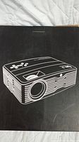 Box with black background and white line drawing of DR.J projector.