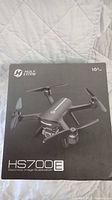 Front of sealed retail box showing Holy Stone logo, drone illustration, model HS700E and age rating