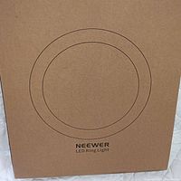 Close-up photo of a Neewer LED Ring Light box showing the brand name and ring design on brown cardboard.