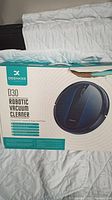 Box showing Deenkee D30 Robotic Vacuum Cleaner branding and features, designed for carpets and hard floors.