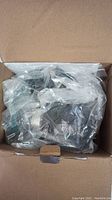 Boxed Tacklife mini circular saw with parts wrapped in plastic inside a cardboard box.