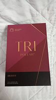 Closed box showing TRI Pollar Desire branding with maroon and black color scheme and gold text.