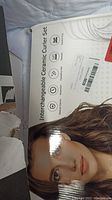 Photo of box with woman's image labeled Interchangeable Ceramic Curler Set highlighting features like ceramic coating and multiple heat settings.