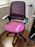 Front view of the purple mesh back adjustable office chair with purple cushioned seat and black armrests on caster wheels