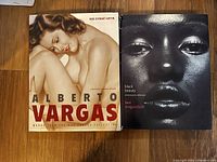 Front covers of the two art books. Left book shows a nude woman illustration by Alberto Vargas. Right book shows a black and white close up photograph of a woman's face titled 'Black Beauty' by Ben Arugundade.