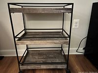 Full view of three tier wooden and rod iron bar cart