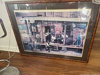 Framed lithograph depicting a blues musicians scene on a rustic porch with vintage objects surrounding them.