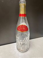 Front view of the Cartier pure crystal champagne bottle showing the red and gold label with brand name and type.