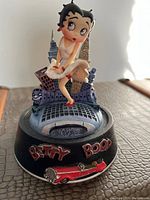 Front view of Betty Boop collectible figurine on cityscape base with 'Betty Boop' text and red vintage car decal.