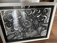 Full view of the framed drawing showing intricate black and white design of a person listening to music with headphones