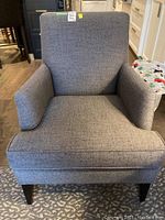 Front view of the grey upholstered arm chair showing overall condition