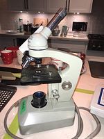 Side angle of Boreal microscope showing base, stage, and power cord