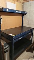 Full front view of blue Mastercraft workbench with pegboard back and drawers