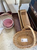 Overview of all six wicker baskets in the set, showing different shapes and colors, including two with handles and varying sizes