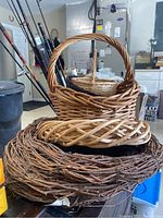 Stack of 4 wicker baskets on top of 3 twig wreaths with varying thickness and colors