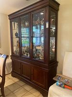 Front view of the wooden china cabinet showing glass doors and lower drawers and doors.