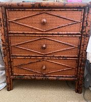 Front view of wicker end table showing three drawers with diamond pattern and bamboo-style frame