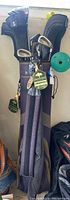 Full view of golf bag containing multiple golf clubs with head covers including 5-wood.