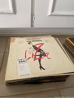 Photo of a stack of mixed artist LP records including a visible cover of Liza Minnelli album.