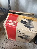 Original box of the Porter Cable 340 finishing sander showing model and branding with signs of wear and partially open box.