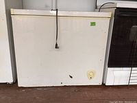 Front view of white chest freezer showing general condition and attached power cord.