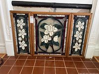 Full frontal view of the three stained glass panels with wooden frames showing overall design and condition.