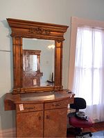 Mirror on top of wooden cabinet reflecting room light and furniture