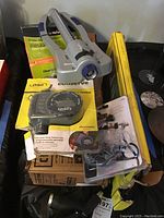 Orbit oscillating sprinkler on top of box, two watering timers visible in opened and unopened packaging along with other boxed items
