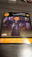 Box front showing Inflatable Pumpkin Reaper figure 4 feet tall with glowing pumpkin head and black cloak, set priced at $19.