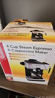 Box of Sunbeam 4 Cup Steam Espresso & Cappuccino Maker with product branding and photo on the front.