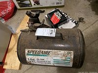 Speedaire branded 5 gallon air tank with label visible, showing used and weathered condition
