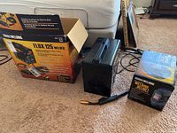 Flux 125 Welding machine in black with original box and instruction manual alongside the boxed auto darkening welding helmet.
