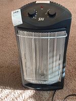 Front view showing controls, brand logo, protective mesh grill, and heater body.