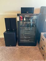 Kenwood stereo components and speakers in black wood cabinet with glass front, scratches visible