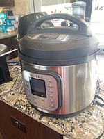 Instant Pot Duo Nova 8 quart stainless steel pressure cooker with digital display on granite counter.
