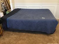 Full view of queen air mattress covered with a blue sheet, showing mattress height and size.