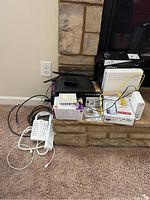 Photo showing NETGEAR router on stone hearth with power strips, cables, and networking boxes.