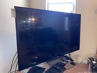 Front view of Sony flat-screen TV with remotes on table