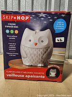 Front view of boxed Skip Hop owl-shaped nightlight soother showing product image and features in English and French.