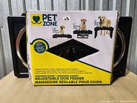 Box showing Pet Zone branding, product image, and size options for adjustable feeder.
