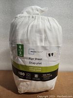Packaged Mainstays queen flat sheet with label showing brand, size, and type