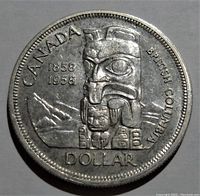 Front side of 1958 Canada $1 silver coin showing totem pole design with inscriptions 1858 1958, Canada, British Columbia, and Dollar.