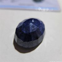 Close-up of oval faceted blue sapphire on white background